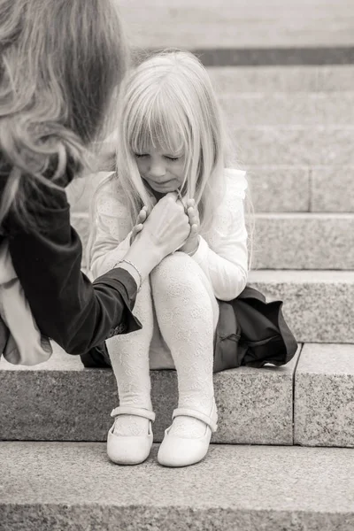 mom comforts crying little daughter. motherhood concept. black and white photo