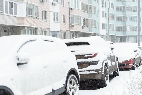 parked car in the yard covered with snow. heavy snowfall