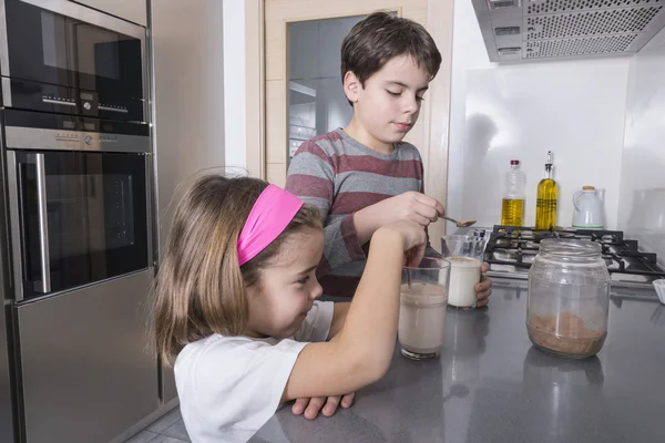 Children preparing a glass of milk — Stock Photo, Image