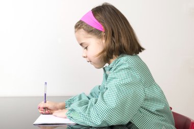Little girl writing in a notebook clipart
