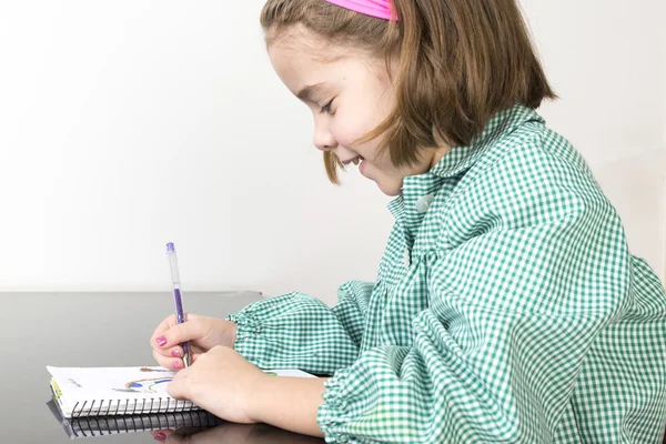 Kleines Mädchen zeichnet in einem Notizbuch — Stockfoto