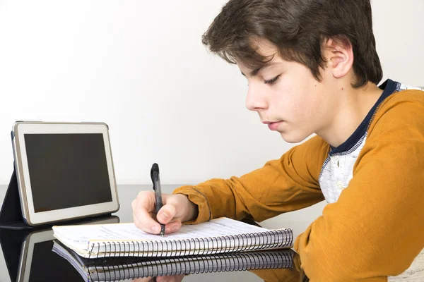 Teenage boy studying with digital tablet at home Royalty Free Stock Images