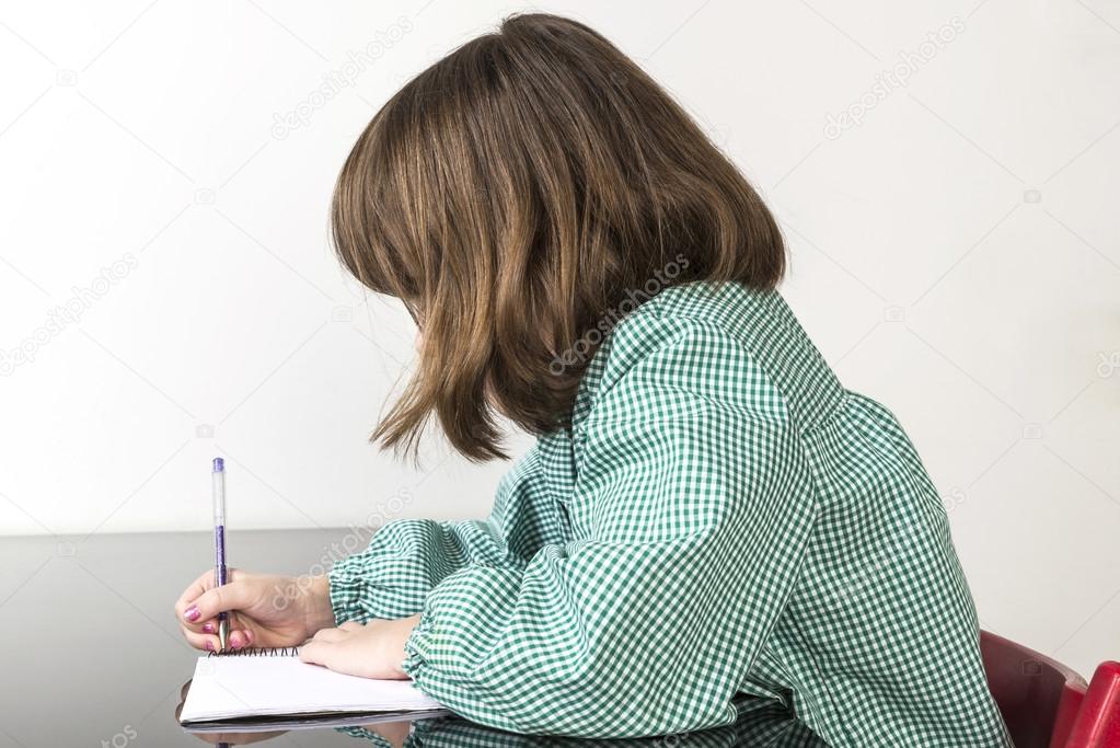 Little girl writing in a notebook