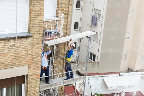 Trabajadores de la construcción trabajando en andamios en Barcelona — Foto de Stock