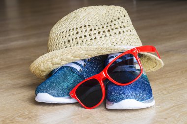 Blue bright sneakers and straw hat with red sunglasses clipart
