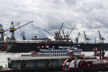 Hamburg, Almanya - 16 Ağustos 2019: Elbe Nehri üzerinde vinçli liman, Pretty Woman reklamlı yolcu gemisi ve Hamburg, Almanya 'da insanlarla dolu bir vapur