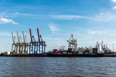 Hamburg, Almanya - 22 Ağustos 2019: Almanya 'nın Hamburg kentinde Elbe Nehri' nde demirlemiş bir konteyner vinci ve kargo gemisi 