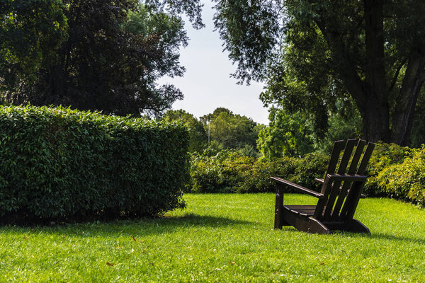 Wooden armchair on a lawn in the Planten un Blomen (Plants and Flowers), urban park in Wallgraben, Hamburg, Germany