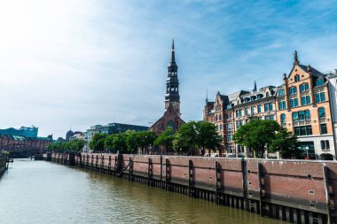 St. Catherine Kilisesi 'nin çan kulesi, St. Katharinen, kanalın yanındaki klasik binalar ve Hamburg, Almanya' daki Elbphilharmonie, Elbe Filarmoni Salonu. 