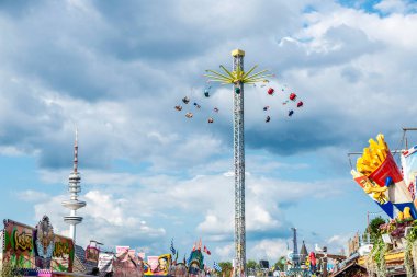 Hamburg, Almanya - 21 Ağustos 2019: Hamburg DOM, yazın lunapark ve Almanya 'nın Hamburg kentindeki telekomünikasyon kulesi etrafında insanların döndüğü sarkaç çekimi 