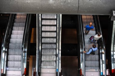 Napoli Centrale tren istasyonu, Napoli Merkez İstasyonu 'nun iç mekanı. Piazza Garibaldi, Napoli, İtalya' da yürüyen merdivende üç adam var.