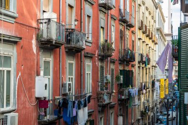 Napoli, İtalya - 6 Eylül 2019: Napoli, İtalya 'nın tarihi merkezindeki balkonda asılı giysileri ve kadınları olan klasik binaların cephesi