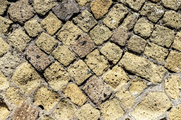 Ancient wall with washed out limestone and remaining concrete as background in the ruins of the ancient archaeological site of Herculaneum in Ercolano, Italy