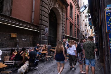 Naples, Italy - September 9, 2019: Spaccanapoli, narrow shopping street with people on the terrace of a bar in the old town of Naples, Italy