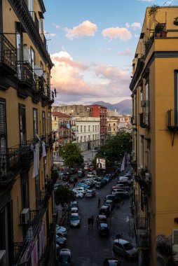 Naples, Italy - September 7, 2019: Overview of a street of classic buildings and the Mount Vesuvius in the old town of Naples, Italy