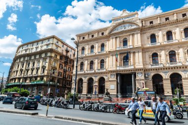 Napoli, İtalya - 9 Eylül 2019: Napoli Ticaret Odası 'nda dört adamla birlikte Napoli, İtalya' dan Giovanni Bovio Meydanı 'nda yürüyen Palazzo della Borsa
