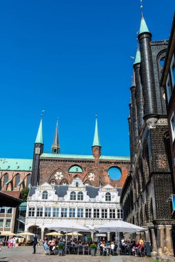 Lubeck, Almanya - 24 Ağustos 2019: Lubeck Town Hall 'da bir teras barı ve Almanya' nın Lubeck kentindeki Pazar Meydanı 'nda insanlar