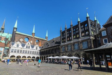 Lubeck, Almanya - 24 Ağustos 2019: Lubeck Town Hall 'da bir teras barı ve Almanya' nın Lubeck kentindeki Pazar Meydanı 'nda insanlar