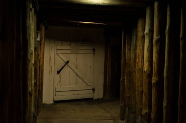 Eski koridorda tahta kirişler ve Wieliczka tuz madeninde kapalı bir kapı var, Krakow, Polonya 
