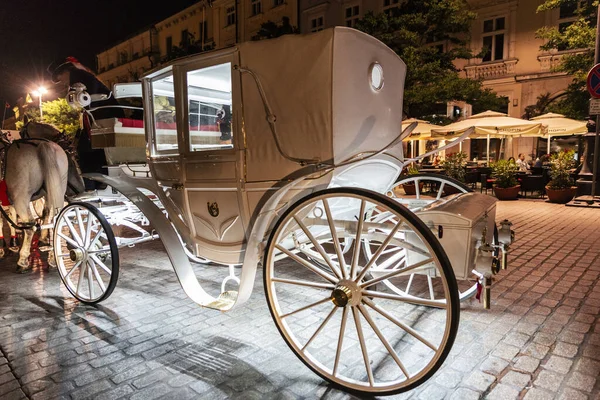 波兰克拉科夫 Krakow 2018年8月29日 在波兰克拉科夫的主要市场广场 Rynek Glowny 人们骑着马在夜间运送游客 在购物街上有餐馆 商店和人群 — 图库照片