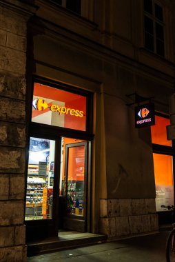 Krakow, Polonya - 29 Ağustos 2018: Krakow, Polonya 'da gece bir Carrefour Express süpermarketinin girişi