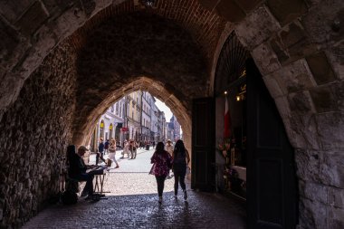 Krakow, Polonya - 30 Ağustos 2018: Florian Gate Tüneli veya Brama Florianska 'da bir müzisyen ve Polonya' nın eski Krakow kentinde yaşayan insanlar
