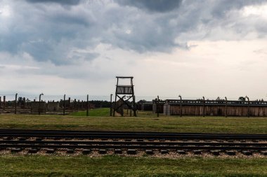 Auschwitz, Polonya - 30 Ağustos 2018: Günbatımında Auschwitz Birkenau toplama kampının elektrikli çiti, 2. Dünya Savaşı sırasında Nazi Almanyası tarafından işletilen bir imha kampı ve Polonya 'nın Krakow kenti yakınlarındaki Yahudi soykırımı 