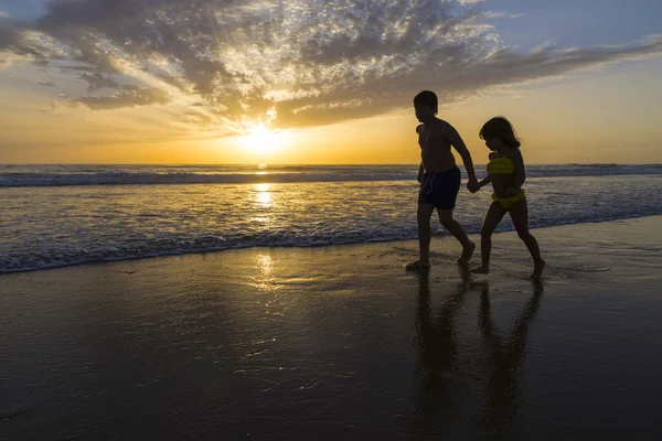 Niños bañándose en la playa al atardecer — Foto de Stock