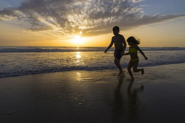 Children bathing on the beach at dusk — Stock Photo, Image