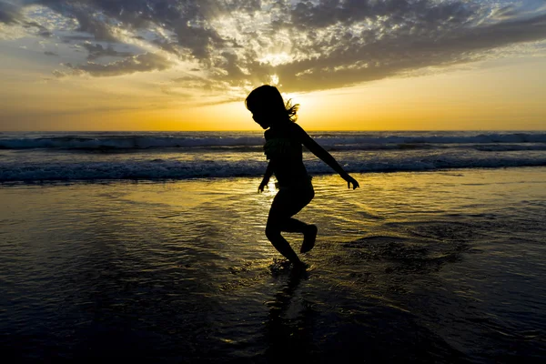 小女孩在黄昏时在沙滩上沐浴 — 图库照片