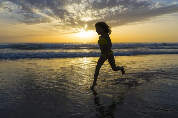 Niña bañándose en la playa al atardecer — Foto de Stock