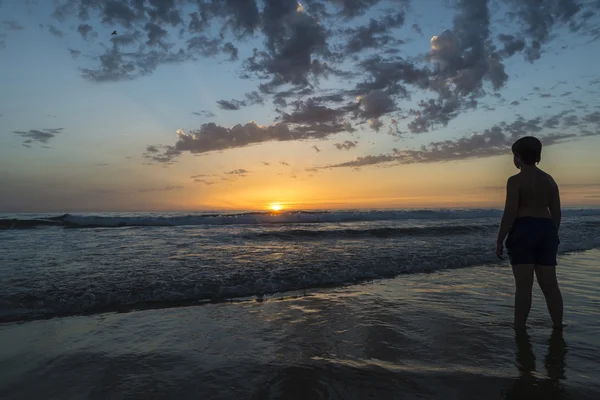 Niño bañándose en la playa al atardecer —  Fotos de Stock