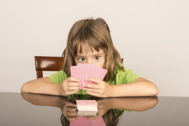 Little girl playing cards clipart