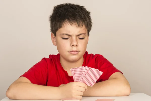 Jovem rapaz jogando cartas — Fotografia de Stock