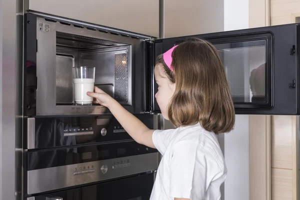 Child preparing a glass of milk — Stock Photo, Image