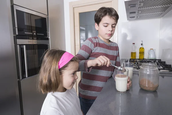 Niños preparando un vaso de leche —  Fotos de Stock