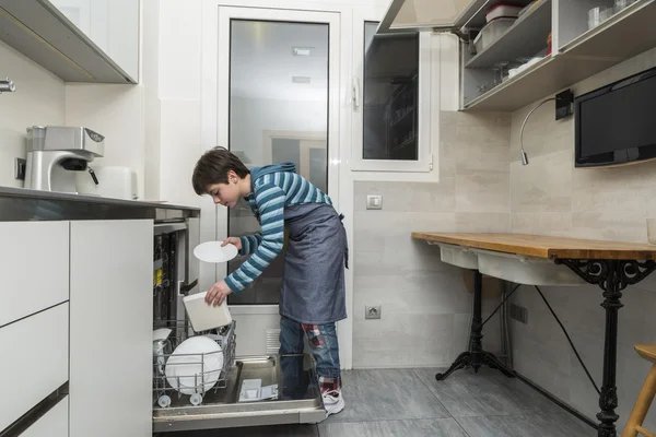 Criança esvaziando a máquina de lavar louça — Fotografia de Stock