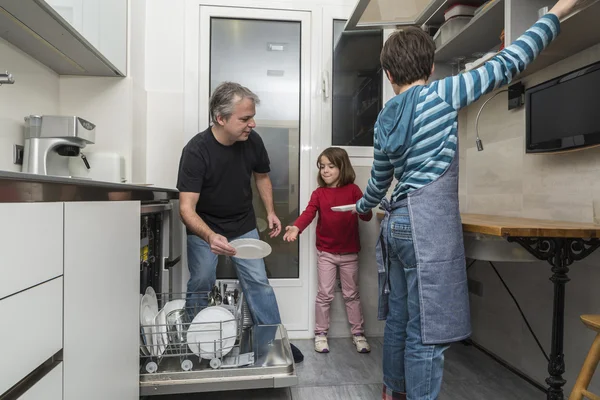 Familie leert die Spülmaschine — Stockfoto