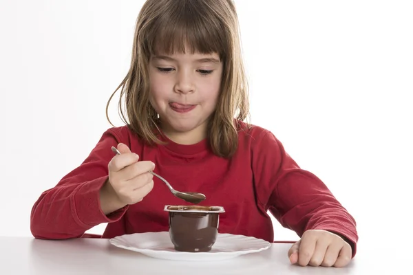 Little girl eating a custard — Stock Photo, Image