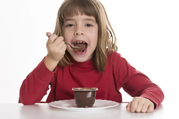 Bambina mangiando una crema pasticcera — Foto Stock