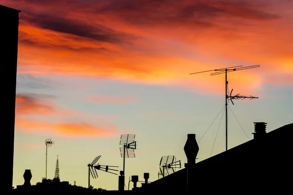 Antennas and chimneys at sunset