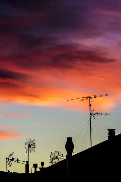 Antennas and chimneys at sunset