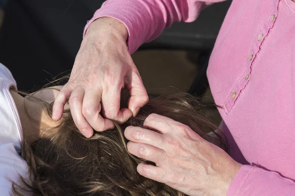 Moeder op zoek naar hoofdluis op haar dochter — Stockfoto