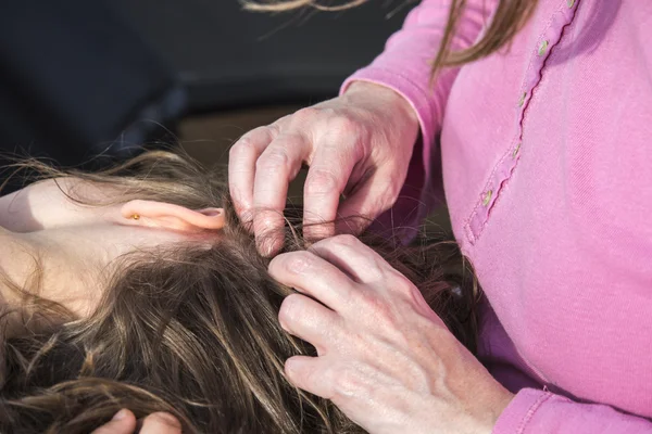 Madre buscando piojos en la cabeza a su hija — Foto de Stock