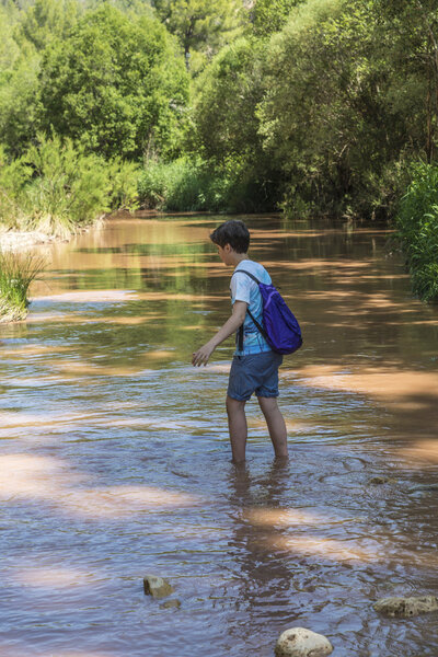 Boy crossing a river