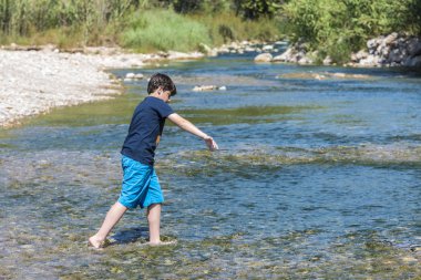 Boy crossing a river clipart