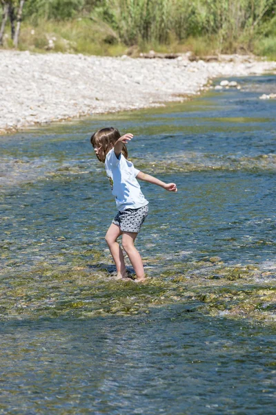 Küçük kız bir nehir geçiş — Stok fotoğraf