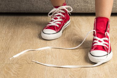 Girl wearing a pair of red sneakers clipart