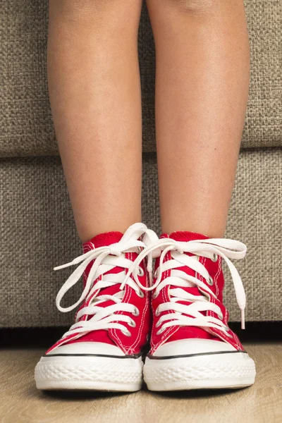 Kız bir çift kırmızı ayakkabı giyiyor