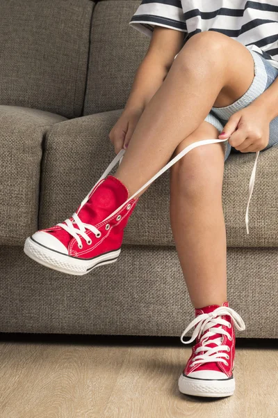 Menina vestindo um par de tênis vermelhos — Fotografia de Stock